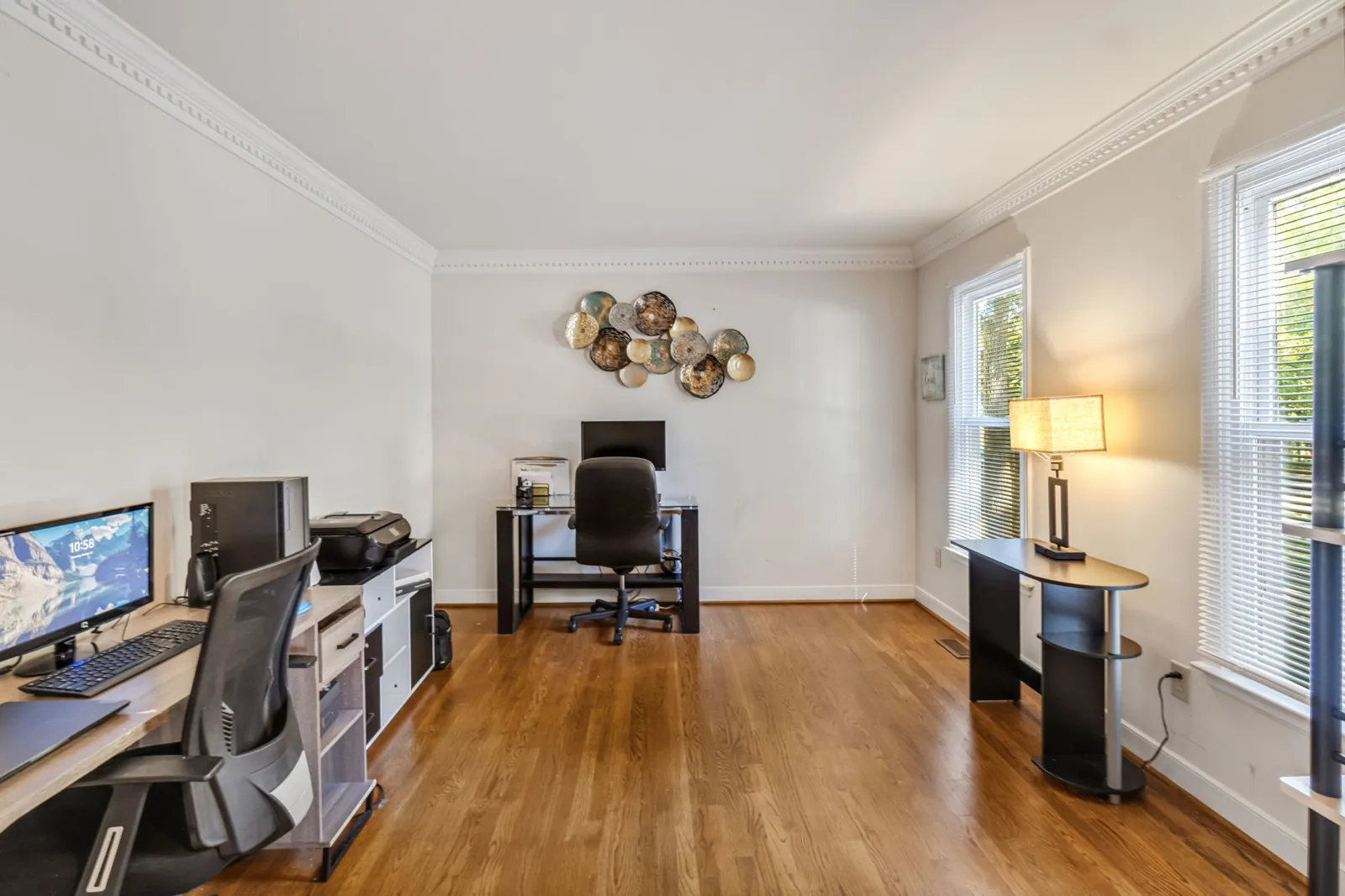 Main-level bonus room with hardwood floors set up as a home office