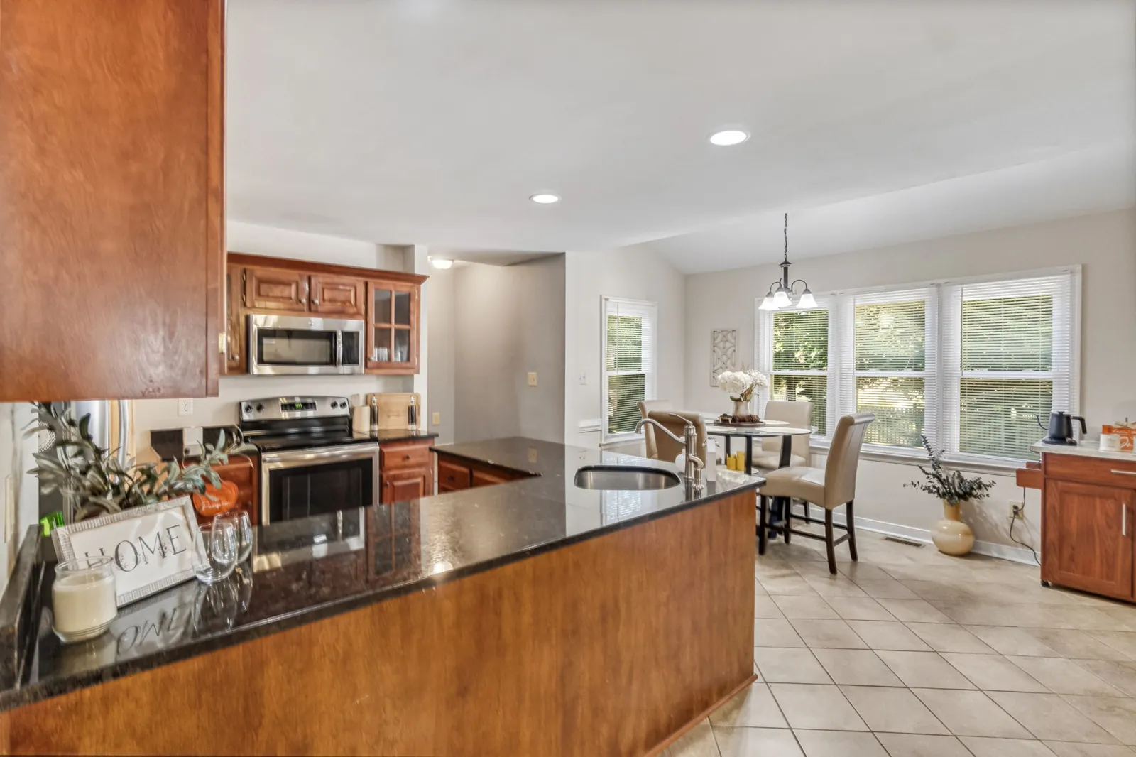 Kitchen with granite counters, stainless appliances, and a sunny breakfast nook