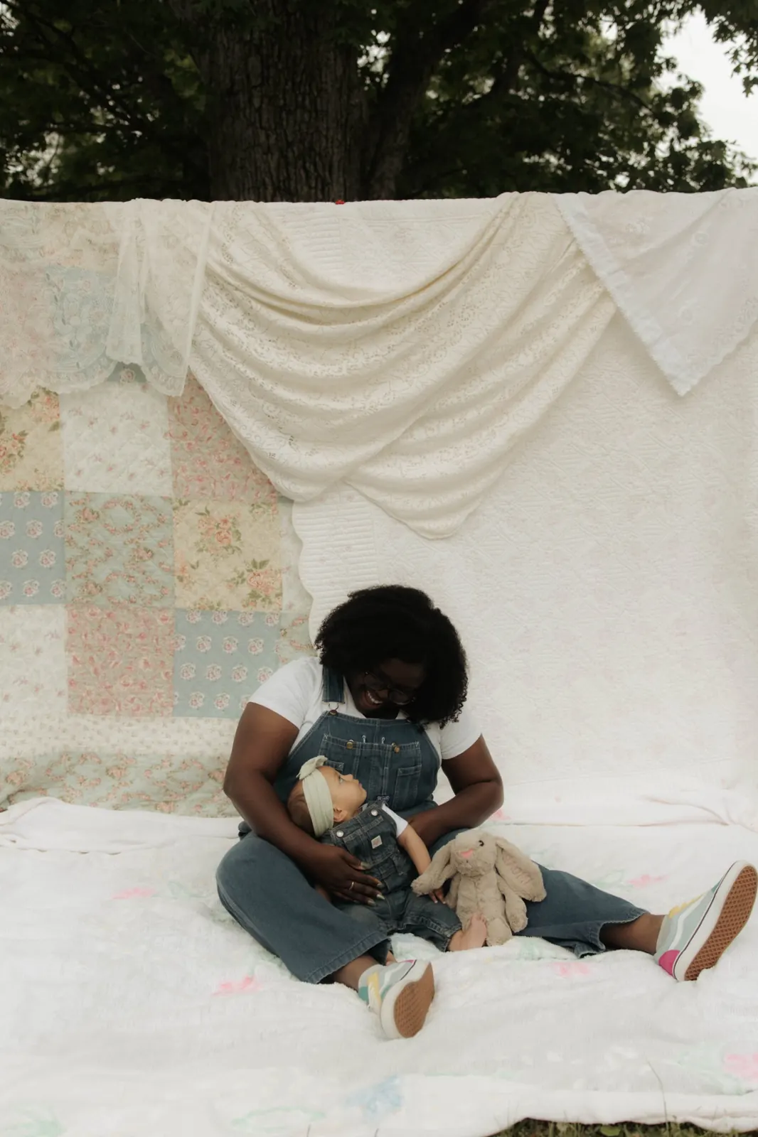 Lavonya laughing with her baby daughter on a vintage quilt