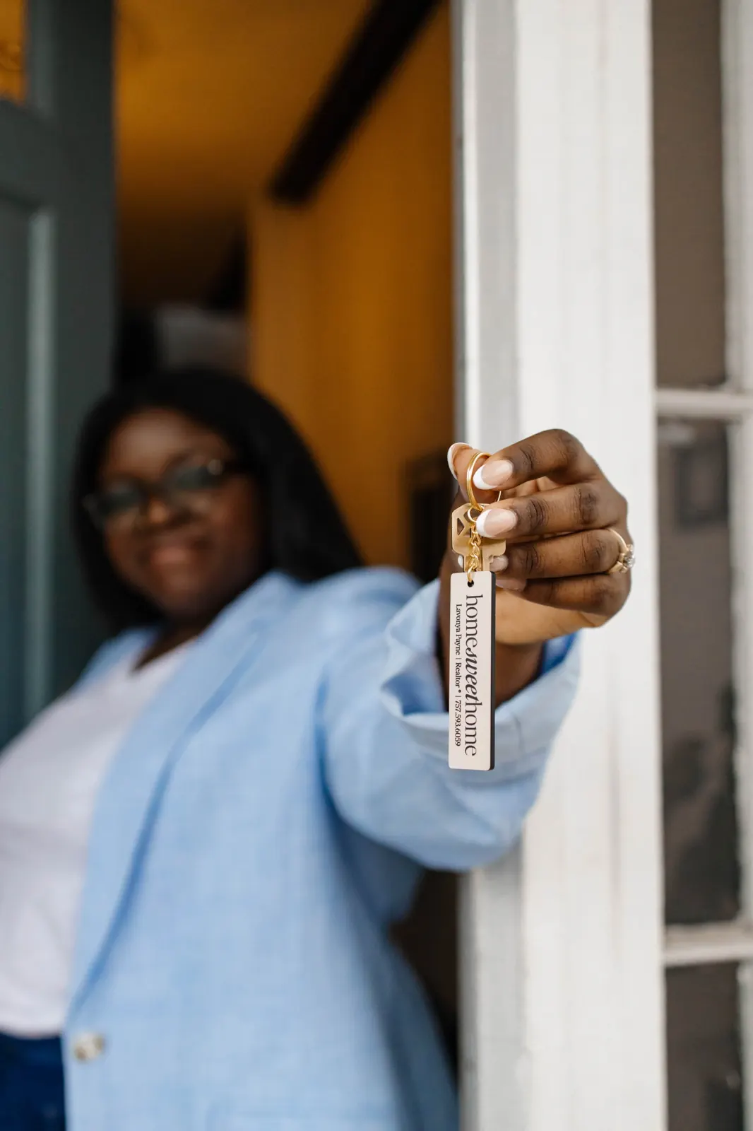 Lavonya handing over house keys on a homeowner keychain