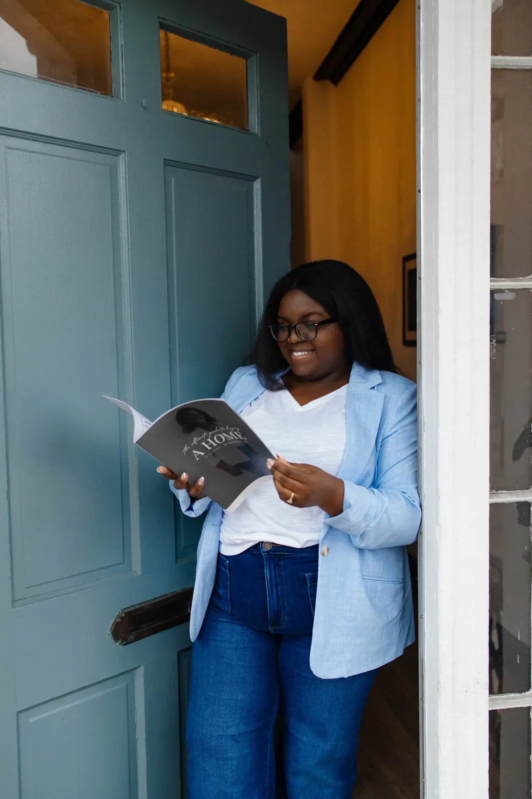Lavonya Payne reading The Ultimate Guide to Buying a Home in Central VA in a doorway